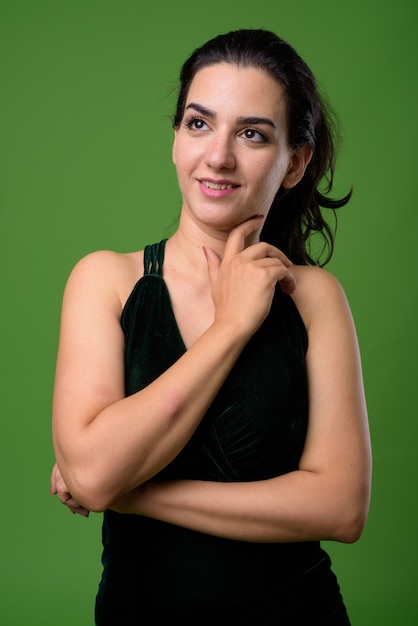 Portrait de la belle femme contre le vert