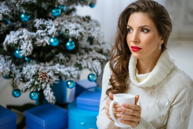 Portrait d'une belle femme dans un pull avec une tasse