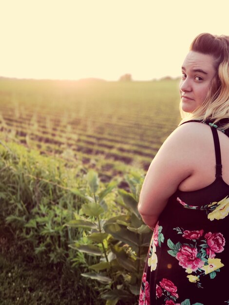 Photo portrait d'une belle femme debout sur un champ contre le ciel