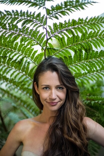 Portrait de belle femme debout à l&#39;extérieur contre les plantes vertes