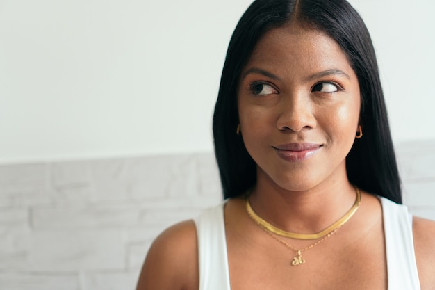 Portrait d'une belle femme debout souriante et regardant sur le côté.