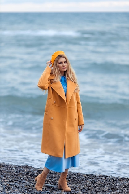 Portrait d'une belle femme élégante dans des vêtements chauds au bord de la mer pendant la saison froide