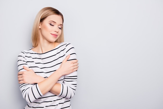 Portrait de la belle femme embrassant ses bras