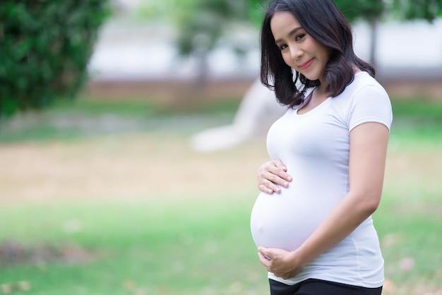 Portrait de belle femme enceinte asiatique au parc