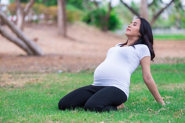 Portrait d'une belle femme enceinte asiatique au parcThailand peopleHappy woman conceptHer jouer au yoga sur la pelouse