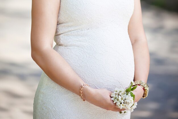 Portrait de la belle femme enceinte dans le parc fleuri. Jeune femme enceinte heureuse, profiter de la vie dans la nature.