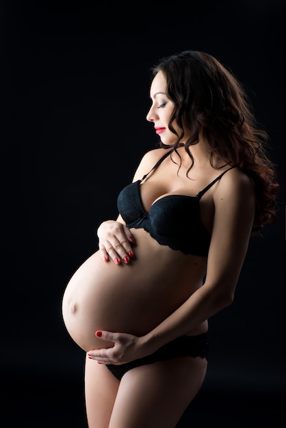 Portrait d'une belle femme enceinte en lingerie noire