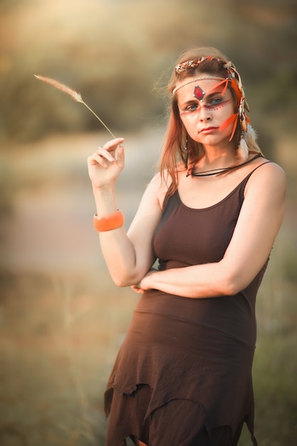 Portrait d'une belle femme ethnique posant en plein air. Maquillage créatif