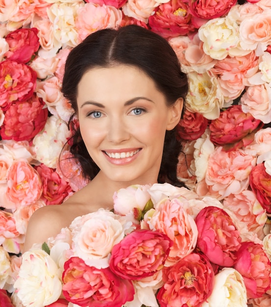 portrait de belle femme avec fond plein de roses