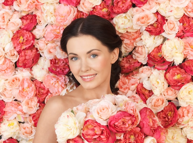 portrait de belle femme avec fond plein de roses