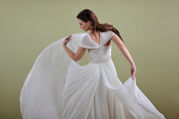 Portrait d'une belle femme habillée en mariée isolée sur fond blanc en studio