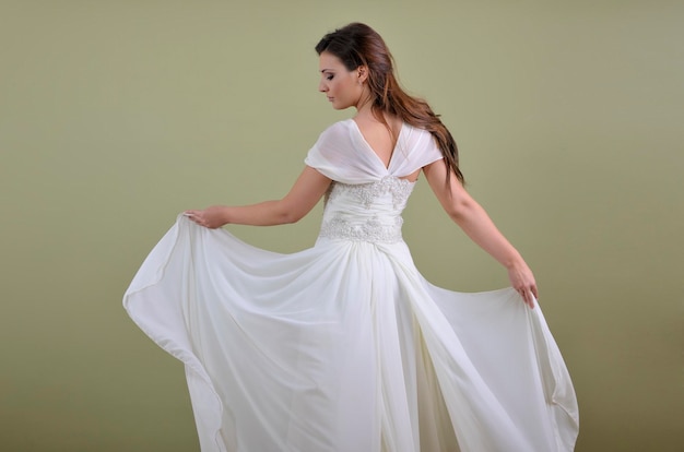 Portrait d'une belle femme habillée en mariée isolée sur fond blanc en studio