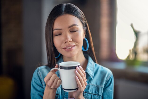 Portrait d'une belle femme heureuse avec une tasse de thé