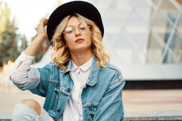 Portrait belle femme avec des lunettes et un chapeau en plein air