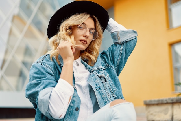 Portrait belle femme avec des lunettes et un chapeau en plein air