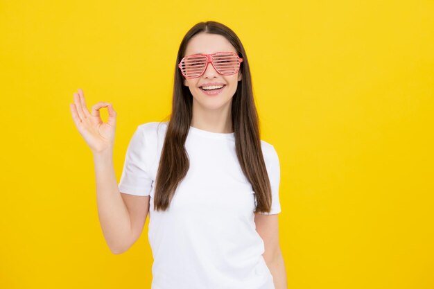 Portrait de belle femme avec des lunettes drôles Célébration et fête Fille s'amusant portrait sur fond jaune