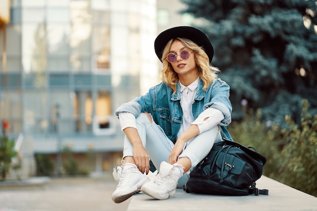 Portrait belle femme avec des lunettes de soleil et un chapeau en plein air