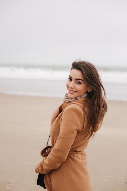 Portrait d'une belle femme marchant le long de la côte près de la mer du Nord Dame élégante en manteau marron