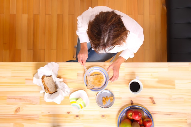 Portrait d'une belle femme mature assise dans la cuisine.