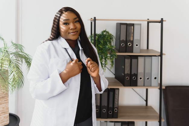 Portrait de la belle femme médecin afro-américain souriant