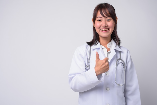 Portrait de la belle femme médecin japonaise sur blanc