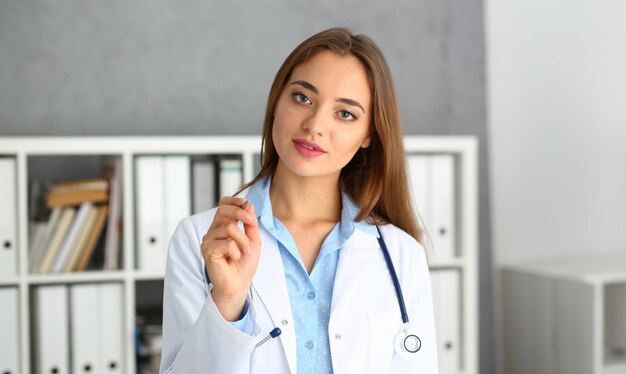 Portrait d'une belle femme médecin tenant un stylo
