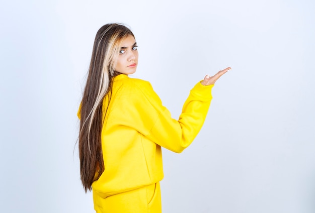 Portrait de belle femme modèle debout et posant en t-shirt jaune