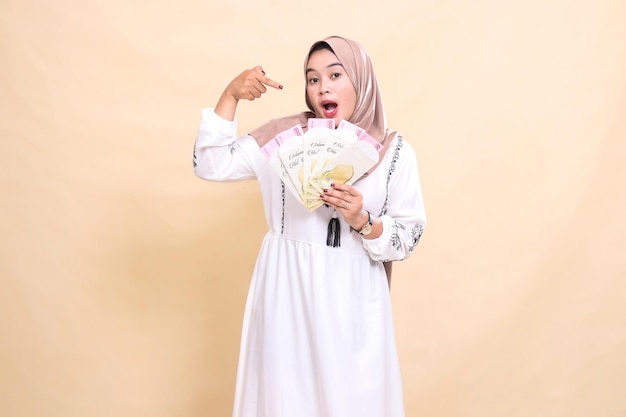 Portrait d'une belle femme musulmane asiatique portant un hijab surprise de montrer des cadeaux et des cadeaux à l'Eid