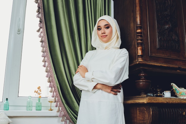 Portrait d'une belle femme musulmane en vêtements islamiques traditionnels et se couvrir la tête