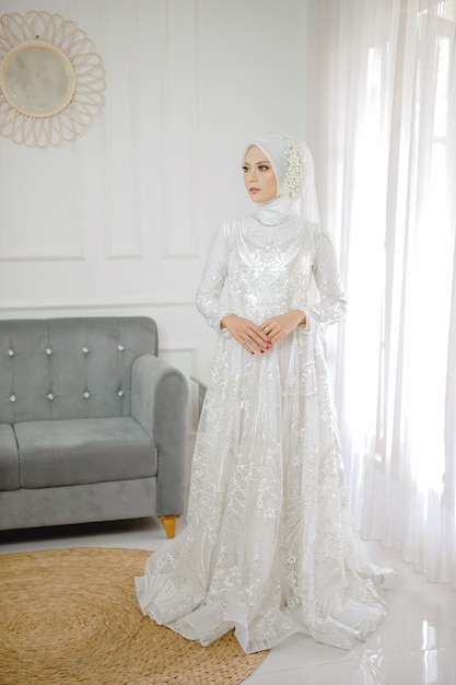 Portrait de la belle femme musulmane vêtue d'une robe de mariée blanche