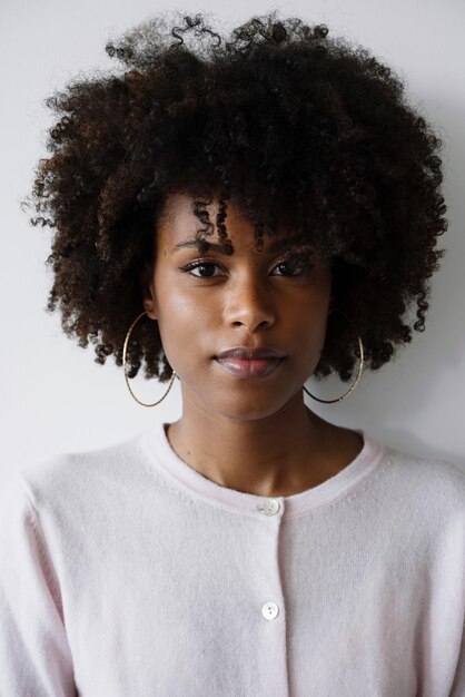 Photo portrait d'une belle femme noire avec un afro sur un fond blanc