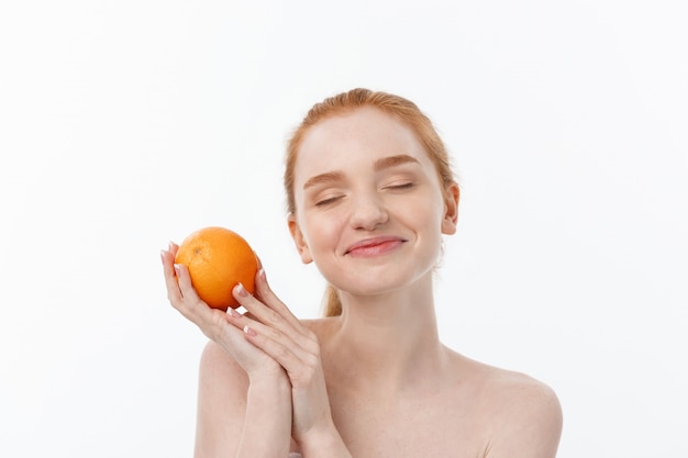 Portrait belle femme avec une orange isolée.