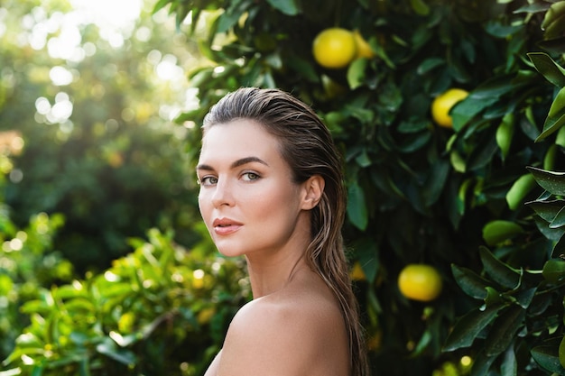 Portrait d'une belle femme à la peau lisse contre les citronniers