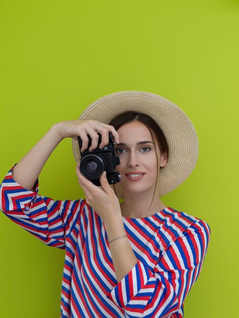 Portrait d'une belle femme photographe tirant en gros plan. Dites "cheese. Jeune femme souriante tenant une caméra isolée sur fond vert