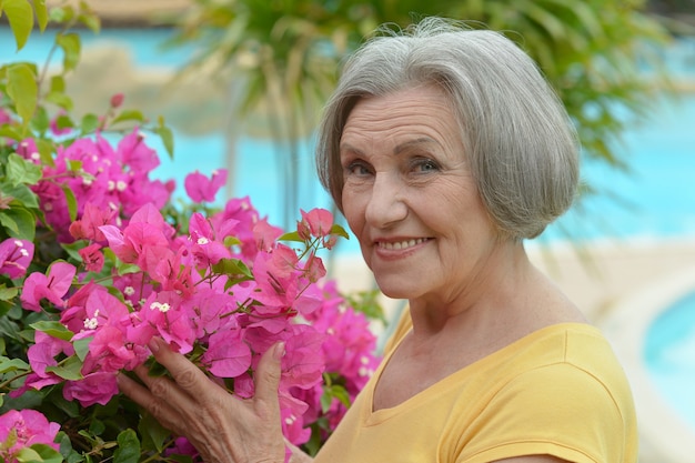 Portrait d'une belle femme plus âgée avec des fleurs