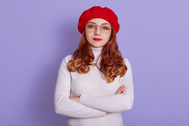 Portrait de belle femme portant chemise blanche et béret rouge