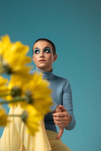 Portrait de belle femme posant dans un col roulé avec des fleurs jaunes