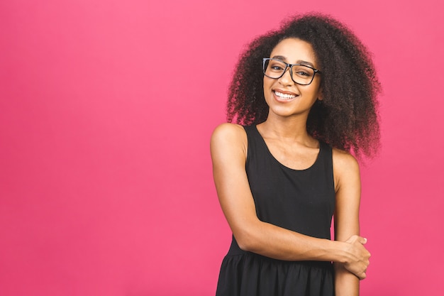 Portrait de la belle femme positive debout sur rose.