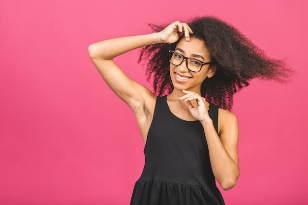 Portrait de la belle femme positive debout sur rose.