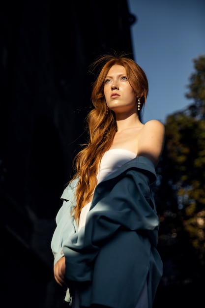 Portrait d'une belle femme rousse dans une chemise bleue