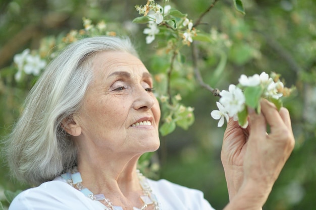 Portrait d'une belle femme senior heureuse dans le parc du printemps