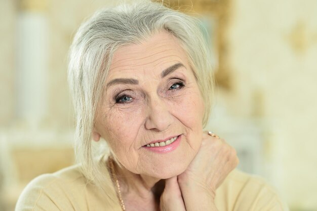 Portrait de belle femme senior heureuse posant à la maison