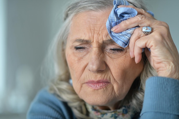 Portrait d'une belle femme senior triste avec des maux de tête