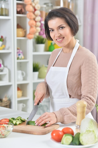 Portrait d'une belle femme souriante faisant cuire à la cuisine