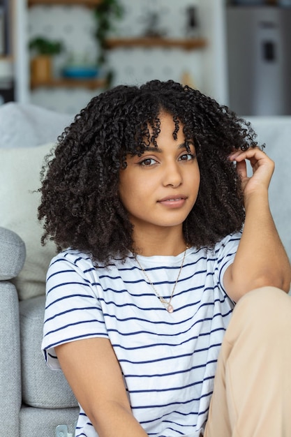 Portrait d'une belle femme souriante à la maison femme africaine en casual regardant la caméra avec un espace de copie jeune fille de race mixte joyeuse se détendant à la maison