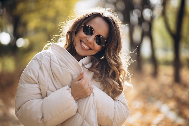 Portrait d'une belle femme souriante et marchant dans le parc