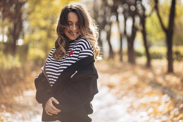 Portrait d'une belle femme souriante et marchant dans le parc