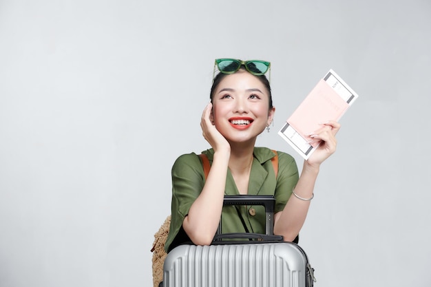 Portrait d'une belle femme souriante tenant un passeport et des billets d'avion