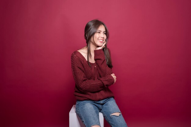 Portrait de belle femme en studio sur fond rouge