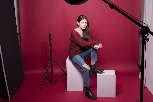 Portrait de belle femme en studio sur fond rouge